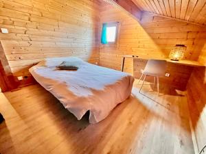 una camera da letto con un letto in una cabina di legno di Maison en bois en 2ème ligne a Gujan-Mestras