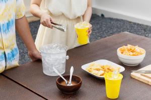 a woman standing at a table with drinks and snacks at Luca Pool Villa in Suan Lang