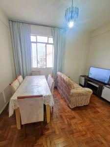 a living room with a table and a couch at Por do Sol nas alturas! Sua solução no centro de BH in Belo Horizonte
