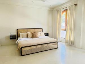 a white bedroom with a large bed and a window at The Suite by Ceilao Villas in Ahangama