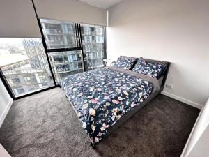 a bedroom with a bed with a floral comforter at Town Center 1 Bedroom Cozy Home in Belconnen