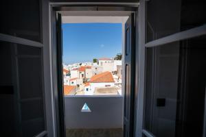 an open door with a view of a city at Kythrooms 1 in Kithnos +6 photos