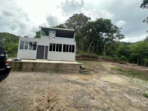 ein kleines weißes Haus auf einer unbefestigten Straße in der Unterkunft Zona de Camping con casa de campo in San Salvador