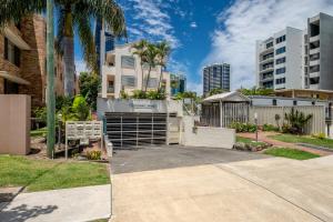 a driveway in front of a building with palm trees at Pets Paradise - Top location with FREE parking in Gold Coast