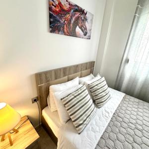 a bedroom with a bed with a painting on the wall at R&T Apartments in Kallithea Halkidikis