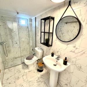 a bathroom with a toilet and a sink and a shower at R&T Apartments in Kallithea Halkidikis +37 photos