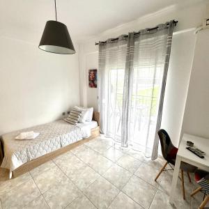 a bedroom with a bed and a large window at R&T Apartments in Kallithea Halkidikis