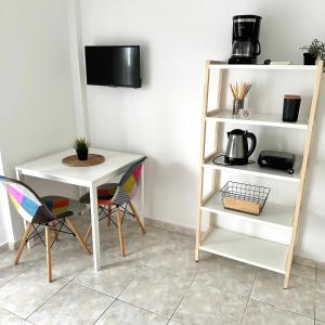 a table and a shelf with a table and chairs at R&T Apartments in Kallithea Halkidikis