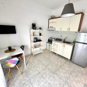 a kitchen with a table and a refrigerator at R&T Apartments in Kallithea Halkidikis