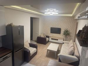 a living room with couches and a flat screen tv at Caribian Apartment in Yerevan +5 photos