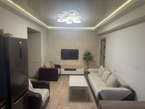 a living room with a couch and a tv at Caribian Apartment in Yerevan