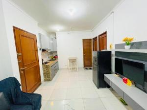 cocina grande con suelo de baldosa blanca en Cozy Room by StayIn Jakarta, en Yakarta