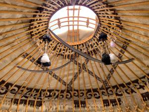 una ventana redonda en un techo de madera con esquís en Yurt Camp NUREL, en Song-Kul 9 fotos más