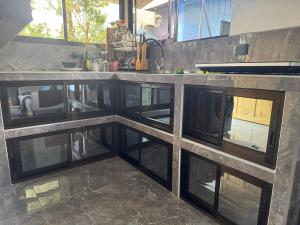 a kitchen with a counter with glass windows at Villa Tucán Fortuna in Fortuna