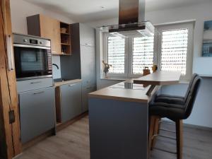 a kitchen with a island with a stove and a microwave at Haus Eldena in Greifswald