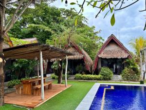 a garden with a picnic table and a swimming pool at Krisna Bungalows and Restaurant in Sekotong