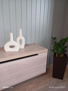 two white vases sitting on top of a dresser at Уютная 2-х комнатная квартира в спальном районе in Shymkent
