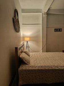 a bedroom with a bed and a lamp in a room at Green Vista Homestay in Silchar