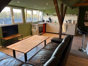 a living room with a couch and a wooden table at Andrews Motobike Apartment in Gelsenkirchen