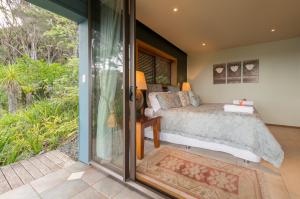 a bedroom with a bed and a sliding glass door at Titore Lodge in Russell
