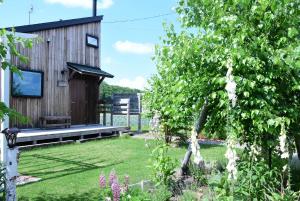 a garden with a wooden house with a tree at mizuki natural villa Garden in Higashikawa