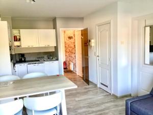 a kitchen with white cabinets and a table and chairs at Just like home De Haan aan Zee in De Haan