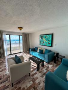 Una sala de estar con dos sofás azules y una mesa. en Deluxe Ocean Villas Marlin, en Cancún