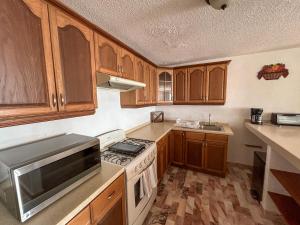 Una cocina con gabinetes de madera y un horno de estufa. en Deluxe Ocean Villas Marlin, en Cancún 4 fotos más