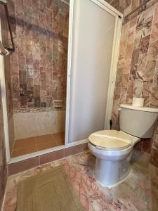 un baño con inodoro y ducha en Deluxe Ocean Villas Marlin, en Cancún
