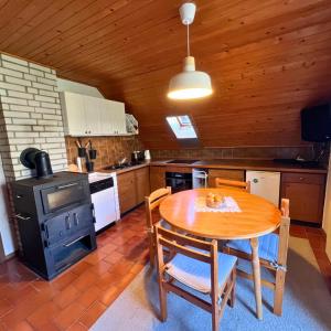 una cocina con una mesa de madera y una estufa en Apartments Korošec Breda, en Bohinj