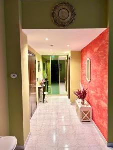 een gang van een huis met een rode muur bij Raf Rhome Seaside - Center 200m to the Sea in Lido di Ostia