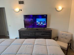 a bedroom with a bed and a television on a dresser at King's Suite Escape in Ontario