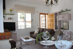 a living room with a couch and a table with wine glasses at Casa Giner in Ciudad Quesada