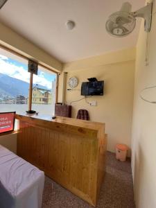 Habitación con barra y ventana con reloj en Hotel Anchal Residency, en Manali