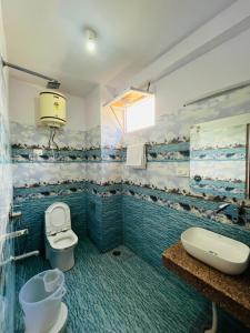 y baño con aseo y lavamanos. en Hotel Anchal Residency, en Manali