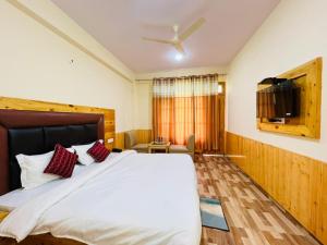 Un dormitorio con una cama grande y un televisor de pantalla plana. en Hotel Anchal Residency, en Manali 35 fotos más