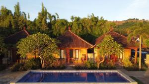 a house with a swimming pool in front of it at Krisna Bungalows and Restaurant in Sekotong