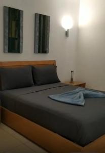 a bedroom with a bed with a blue shirt on it at Apart Hotel Vila Verde in Santa Maria