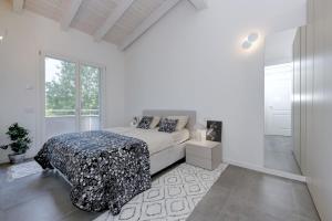 a white bedroom with a bed and a window at Sweet Dreams in Rivoltella +38 photos