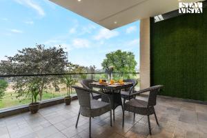 Una mesa y sillas en un balcón con vista. en StayVista at Stay-ish Villa with Pool, Wi-Fi, BBQ, en Amritsar