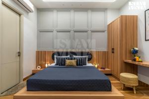 Un dormitorio con una cama con una colcha azul. en StayVista at Stay-ish Villa with Pool, Wi-Fi, BBQ, en Amritsar