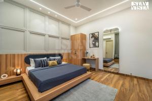 Un dormitorio con una cama tamaño king en una habitación en StayVista at Stay-ish Villa with Pool, Wi-Fi, BBQ, en Amritsar