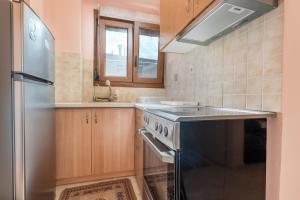 a kitchen with a stove and a refrigerator at Mytilene Central Home 2 in Mytilini +2 photos