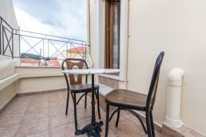 a table and two chairs on a balcony at Mytilene Central Home 2 in Mytilini