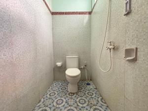 a bathroom with a toilet and a shower at Krisna Bungalows and Restaurant in Sekotong
