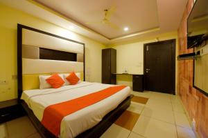 a bedroom with a large bed with orange pillows at Collection O Tip Top in Jaipur +37 photos
