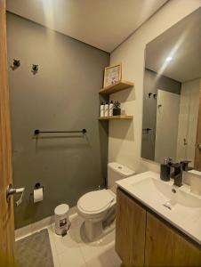 a bathroom with a toilet and a sink and a mirror at AH/ Loft panorámico Industrial, Wifi350Mg, Usaquén in Bogotá