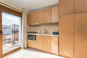 ミティリニにあるMytilene Central Home 3の木製キャビネット付きのキッチン、バルコニーが備わります。