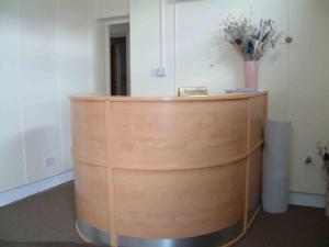 a wooden podium in an office with a vase of flowers at The Lodge Guest Accommodation in Barrow in Furness