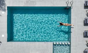 Ein Mann schwimmt in einem Schwimmbecken in der Unterkunft Villa Daratso with private heated pool view to the sea in Daratso